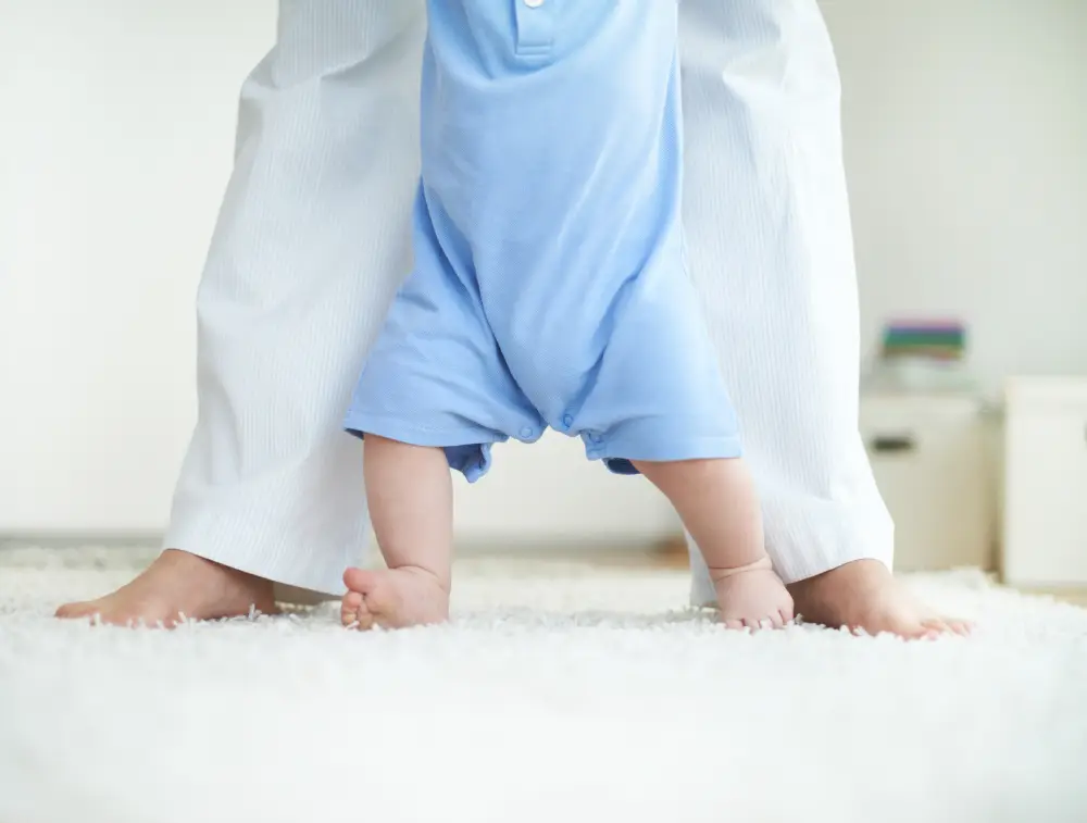 Close-up of female and little baby legs during walk down the floor